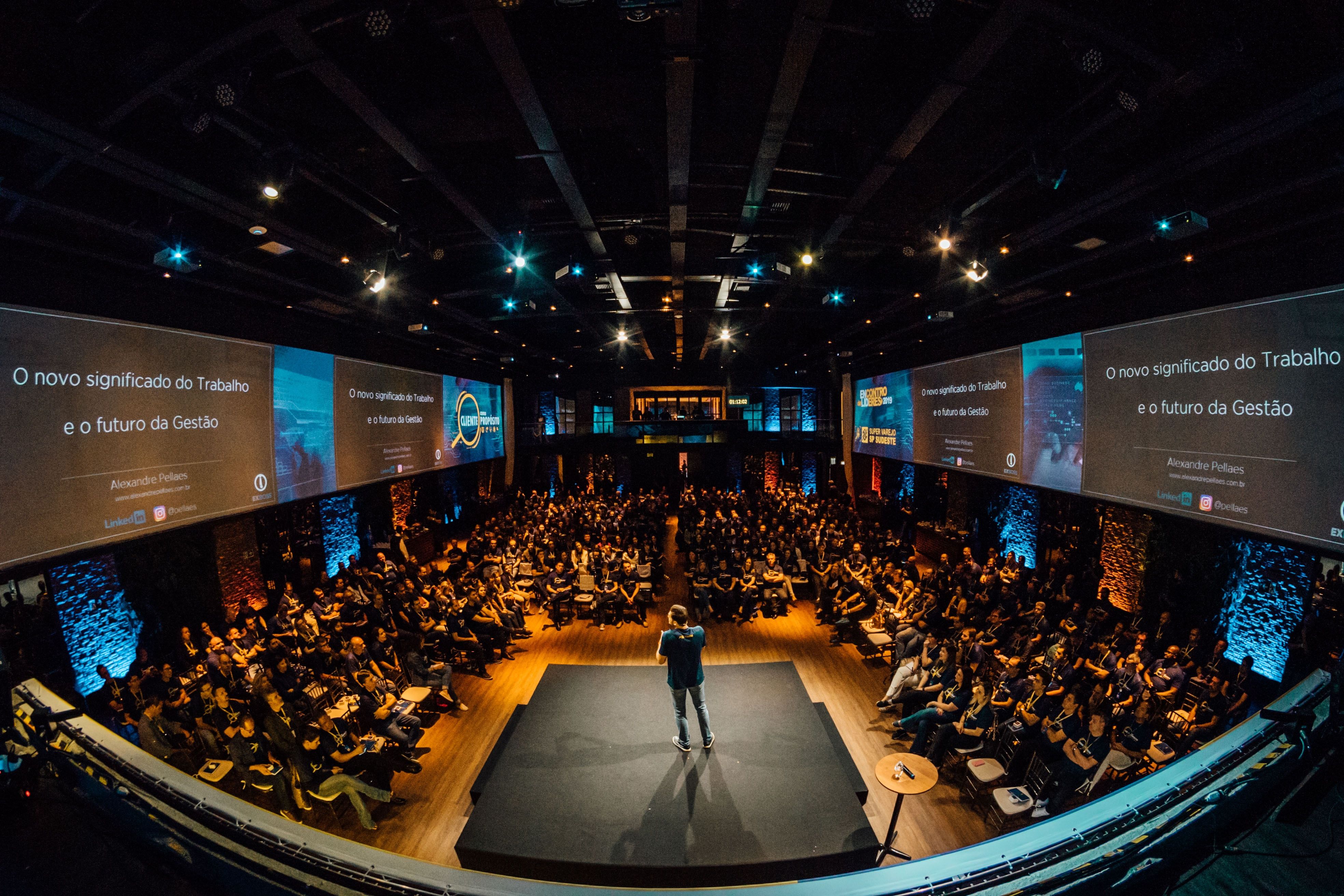 Shows a conference with stage and people